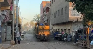 لحظة عبور قطار القصب بين المنازل بقنا